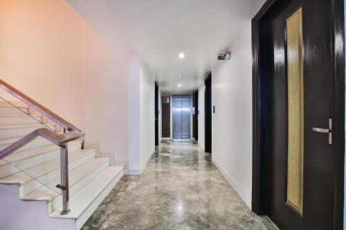 a hallway with white walls and stairs with a door at Hotel Uppal International in New Delhi