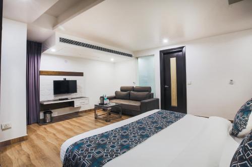 a hotel room with a bed and a couch at Hotel Uppal International in New Delhi