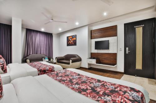 a hotel room with two beds and a flat screen tv at Hotel Uppal International in New Delhi