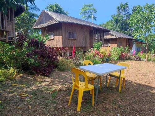 a table and chairs in front of a house at Virgin River Resort and Recreation Spot in Bolinao