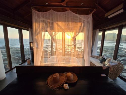 a room with a bed with a window with a hat at Full Moon Island Resort in Kaoh Sdach