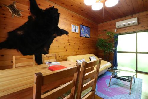a wooden room with a table and a bed in it at なごみの里 in Shionoe