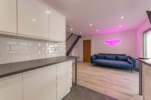 a kitchen with a blue couch in a room at Modern Fully Renovated 4 Bedroom in Cwm-brân