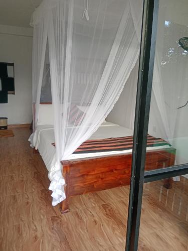 a bedroom with a bed with white mosquito nets at Ella glory inn in Ella