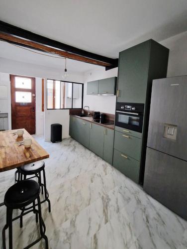 une grande cuisine avec des placards verts et une table en bois dans l'établissement RINALDI 57 Maison typique du Pont Vieux, à Albi