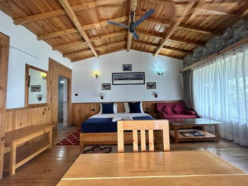 a bedroom with a bed and a wooden ceiling at Kasar Himalaya Holiday Resort, Binsar Rd in Almora