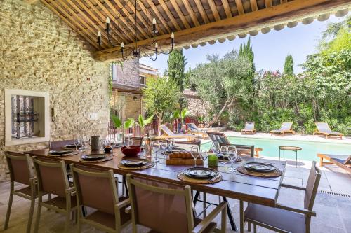 une salle à manger extérieure avec une table et des chaises ainsi qu'une piscine dans l'établissement Oasis de Gordes, à Gordes