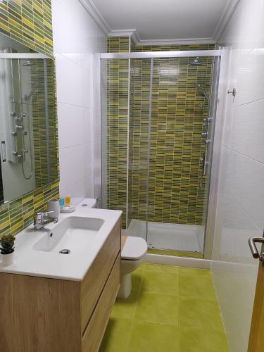 a bathroom with a sink and a shower and a toilet at Melide Suites By OL in Melide