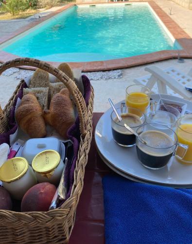 - un panier de nourriture sur une table à côté de la piscine dans l'établissement La roulotte de La Motte, à La Motte