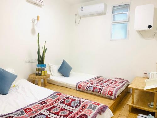 a room with two beds and a window at 笑脸里青年旅舍宽窄店 in Chengdu