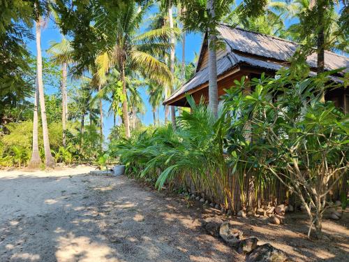 a house with palm trees next to a road at Full Moon Island Resort in Kaoh Sdach