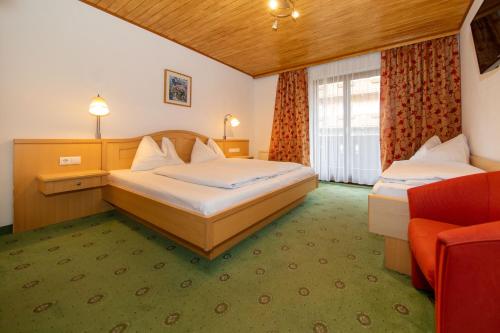 a hotel room with two beds and a couch at Pension Mozart in Wagrain