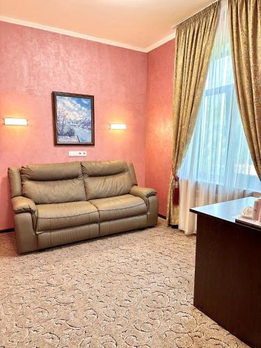 a living room with a couch and a window at VLG Hotel in Boryspilʼ