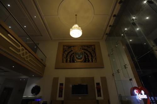 a chandelier hanging from the ceiling of a building at THE GRAND ASTORIA SOMANTH by Shivalaya Darshanam in Somnath