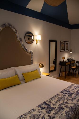 a bedroom with a large white bed with yellow pillows at Maison Primado B&B in Valencia