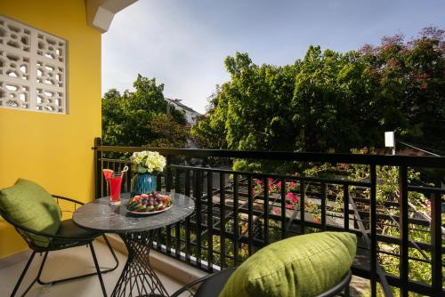 a balcony with a table with a bowl of fruit on it at Hoi An Golden Holiday Villa in Hoi An
