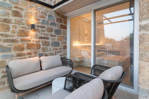 a living room with a couch and chairs on a patio at Gialova Hills 8 - Luxury Apartments with Pool in Gialova