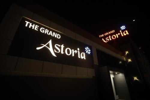 a sign on the side of a building at night at THE GRAND ASTORIA SOMANTH by Shivalaya Darshanam in Somnath