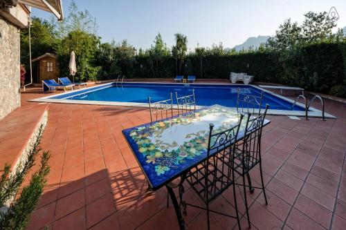 a swimming pool with a table in front of it at Lady Food Location in Cava deʼ Tirreni
