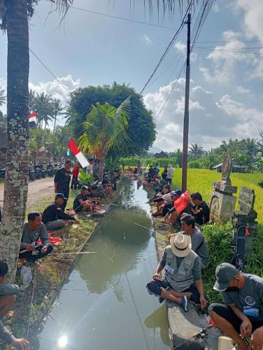 a group of men sitting on the side of a river at Bali Bakas House II in Banjarangkan