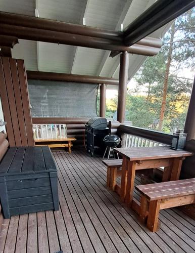 a screened in porch with benches and a grill at Äijänhonka Cottage in Jämsä