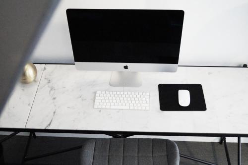 a computer monitor and a keyboard on a desk at Hotel Bella Italia in Sønderborg