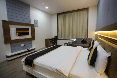 a hotel room with a bed and a television at THE GRAND ASTORIA SOMANTH by Shivalaya Darshanam in Somnath