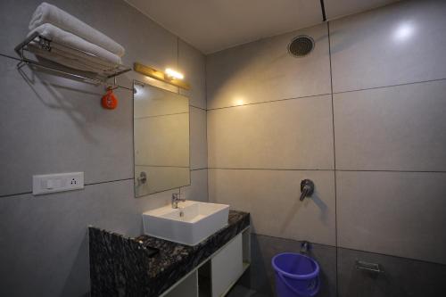 a bathroom with a sink and a mirror at THE GRAND ASTORIA SOMANTH by Shivalaya Darshanam in Somnath