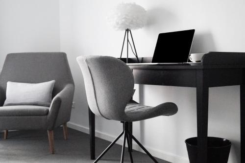 a desk with a laptop computer and a chair at Hotel Bella Italia in Sønderborg