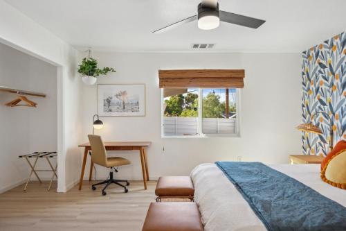 a bedroom with a bed and a desk and a window at Tangerine House - Hot Tub, Fire Pit, BBQ! home in Joshua Tree
