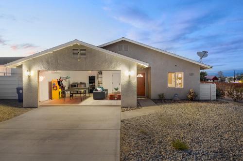 a house with the door open to a patio at Tangerine House - Hot Tub, Fire Pit, BBQ! home in Joshua Tree