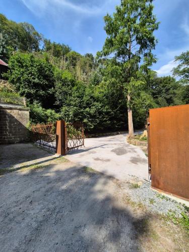 an entrance to a driveway with a gate and trees at Ferienhaus zum Wehlener Grund in Stadt Wehlen