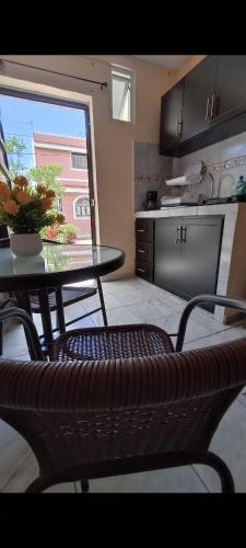 a table and chairs in a kitchen with a table and a window at Habitación principal en Mazatlán in Mazatlán