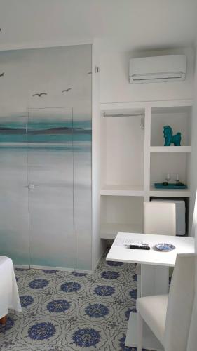 a room with a white table and chairs and a floor at B&B "Raggio di Sole" in Le Castella