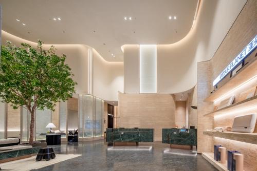 eine Lobby mit einem Baum in der Mitte eines Gebäudes in der Unterkunft Atour S Hotel Shenzhen Nanshan Science and Technology Park Hi-Tech Centre in Shenzhen