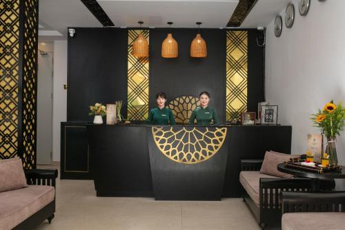 two women sitting at a bar in a restaurant at Hoi An Golden Holiday Villa in Hoi An