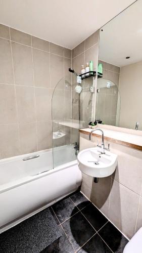 a bathroom with a sink and a toilet and a tub at Cozy Bedroom in Birmingham City Centre in Birmingham