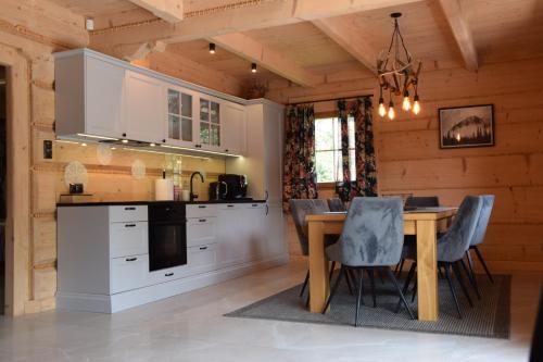 a kitchen and dining room with a table and chairs at Willa Góralka in Szczyrk