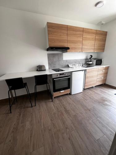 une cuisine avec des armoires en bois et un comptoir dans l'établissement Appart hotel La Molle, à Berre-lʼÉtang