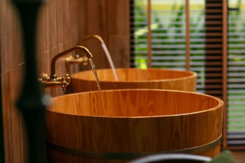 a wooden tub with a water fountain in a bathroom at Hoi An Golden Holiday Villa in Hoi An
