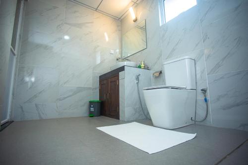 a white bathroom with a sink and a toilet at Echoing Dream Resort in Galle