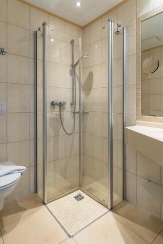 a shower with a glass door in a bathroom at Inselhotel Rote Erde in Borkum