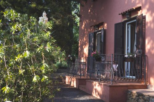 a house with a balcony with flowers on it at Podere San Filippo B&B-Apartment-Pet Friendly-Rent Bike and Bike Friendly in Bibbona