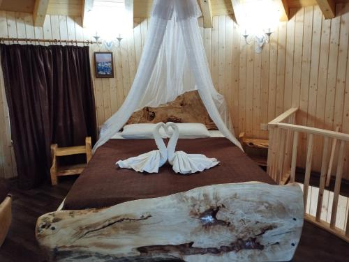 una camera da letto con un letto con due abiti bianchi sopra di Приказната къщичка на Смърфовете a Krayni Dol