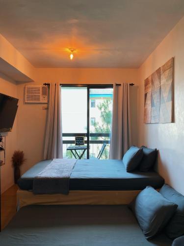 a bedroom with a large bed and a balcony at Coco's Tagaytay in Tagaytay