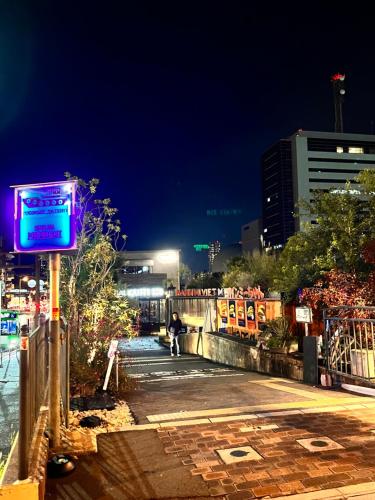 a city street at night with a neon sign at 星の宿 in Osaka