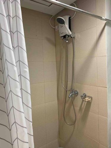 a shower with a shower head in a bathroom at Coco's Tagaytay in Tagaytay
