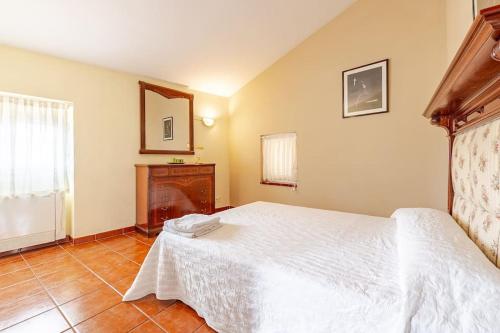 a bedroom with a white bed and a fireplace at Hort de la Cinteta in Alcover