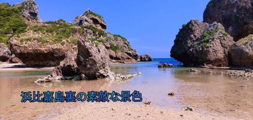 a beach with some rocks in the water at Independent House 沖縄VILLA YASUMIBA Okinawa Uruma in Uruma