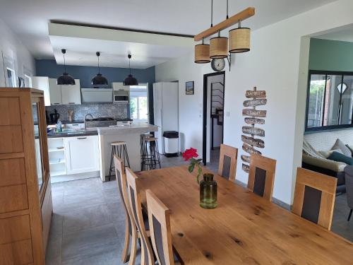 a kitchen and dining room with a wooden table and chairs at chez jules, l'entrée des caps in Bazinghen